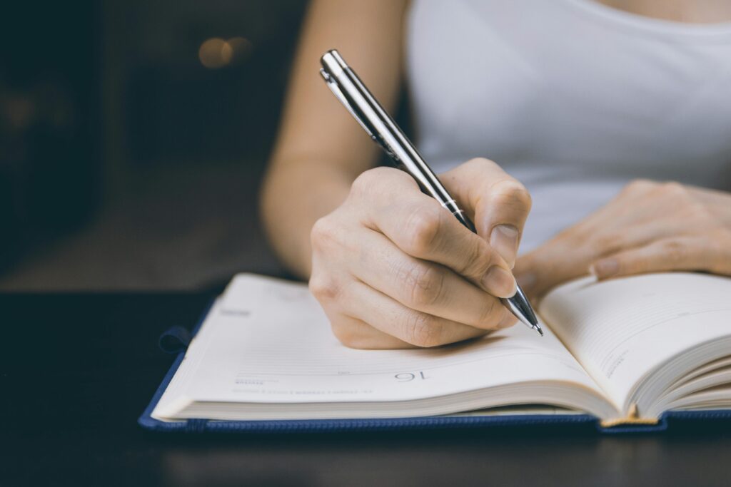 a woman journaling at home on her notebook
what to do when bored activities